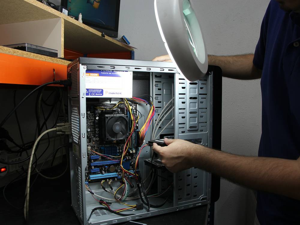 Techniker baut eine Festplatte in einen geöffneten Desktop-PC ein