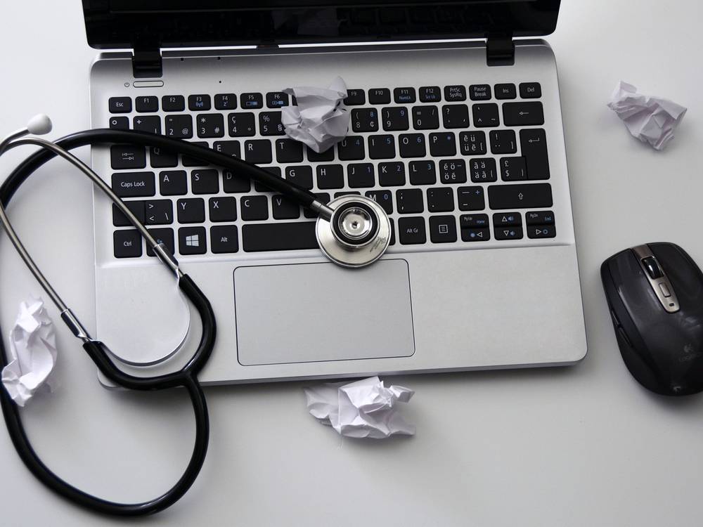 Notebook mit Stethoskop auf der Tastatur als Sinnbild für die Fehlerdiagnose