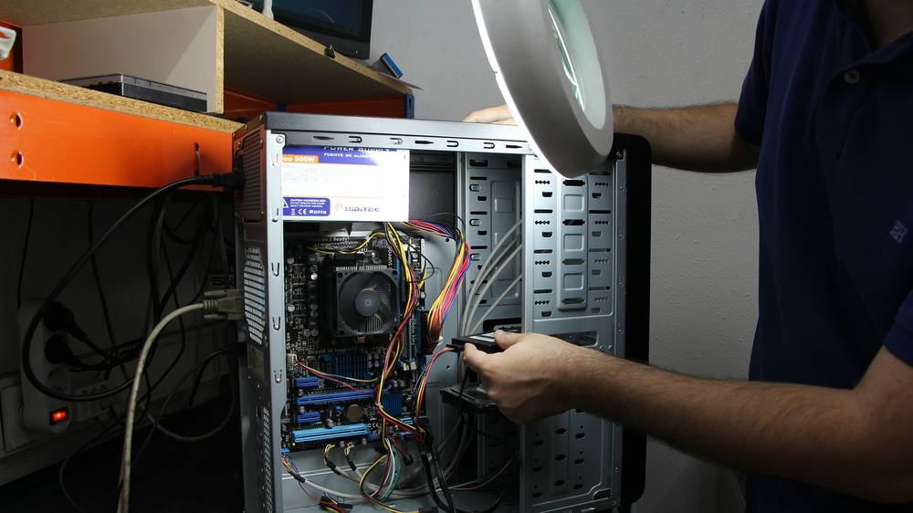 Techniker baut eine Festplatte in einen geöffneten Desktop-PC ein
